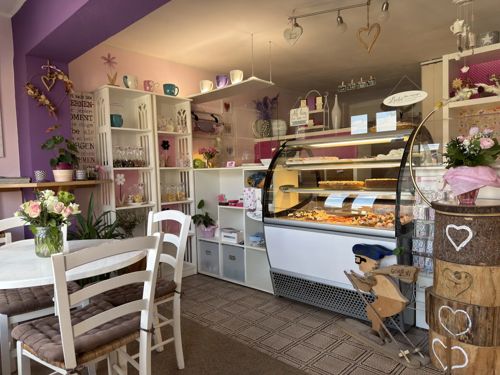 Gemütlicher Innenraum von Silvias Backstube mit Vitrine, weißen Möbeln und liebevoller Dekoration