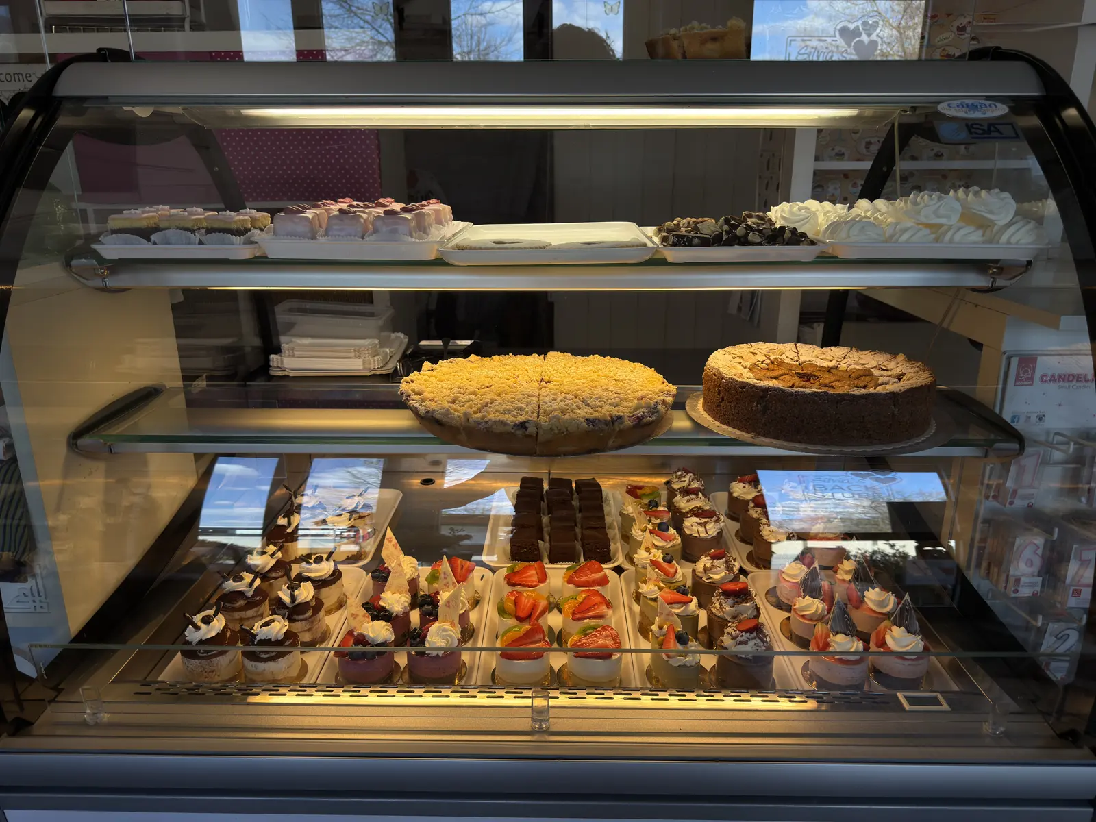 Vitrine voller frischer Torten, Cupcakes und Desserts in Silvias Backstube